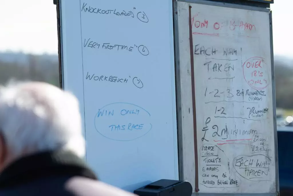 a man standing next to a white board with writing on it